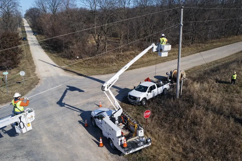 OSP construction crew with bucket trucks placing aerial fiber